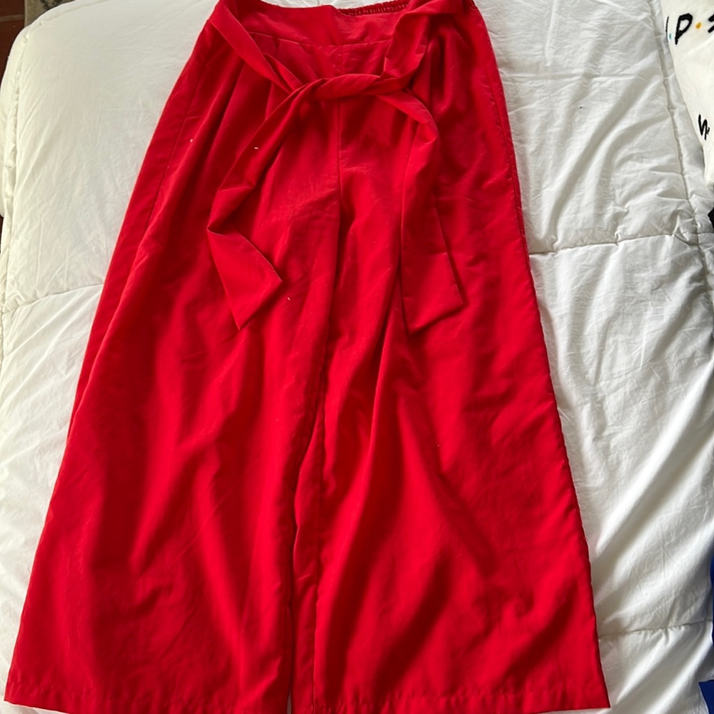 Red pants that flow out at the ankle and tie at the waist.